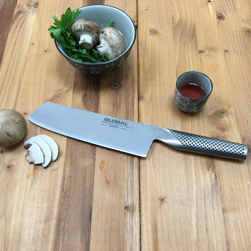 Cuchillo Global G-5 sobre superficie de madera, perfil de hoja ancha nakiri
