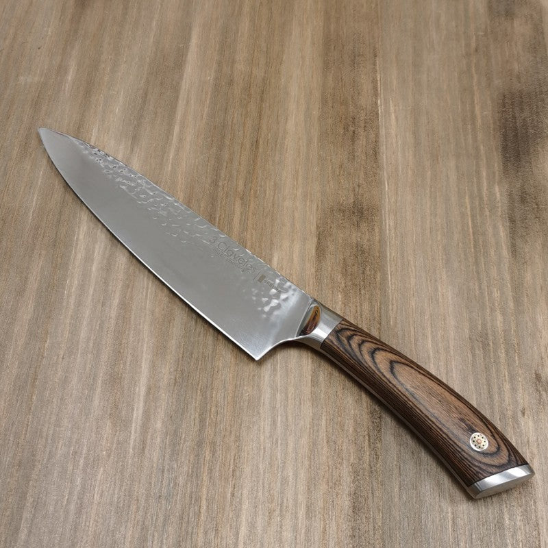 Cuchillo cocinero Sakura 3 Claveles cortando carne sobre tabla de madera