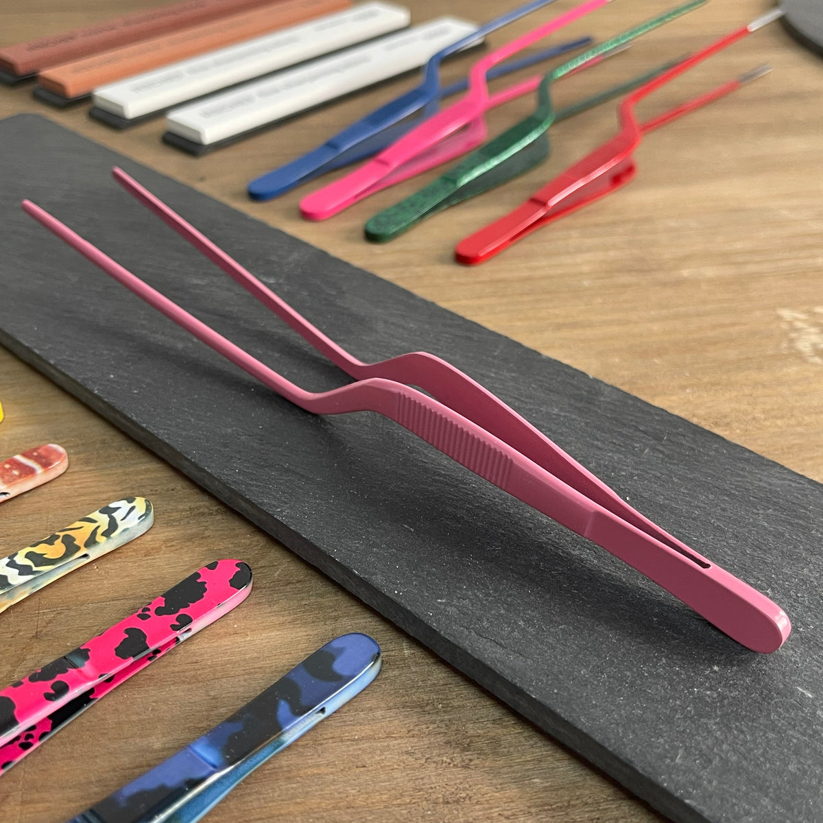 Pinza chef rosa mate con puntas dentadas para emplatado preciso y decoración
