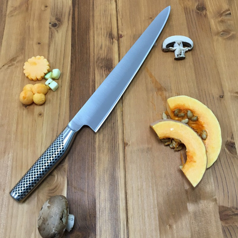 Cuchillo Global G-19 fileteador sobre superficie de madera, perfil de hoja flexible larga