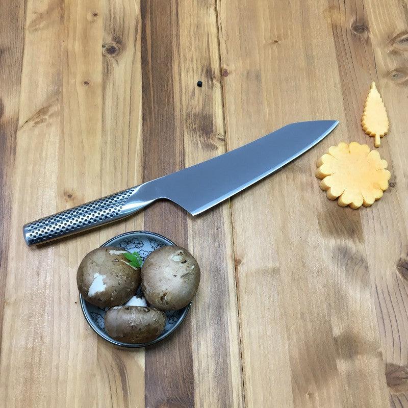 Cuchillo Global G-4 oriental sobre superficie de madera, perfil de hoja japonés