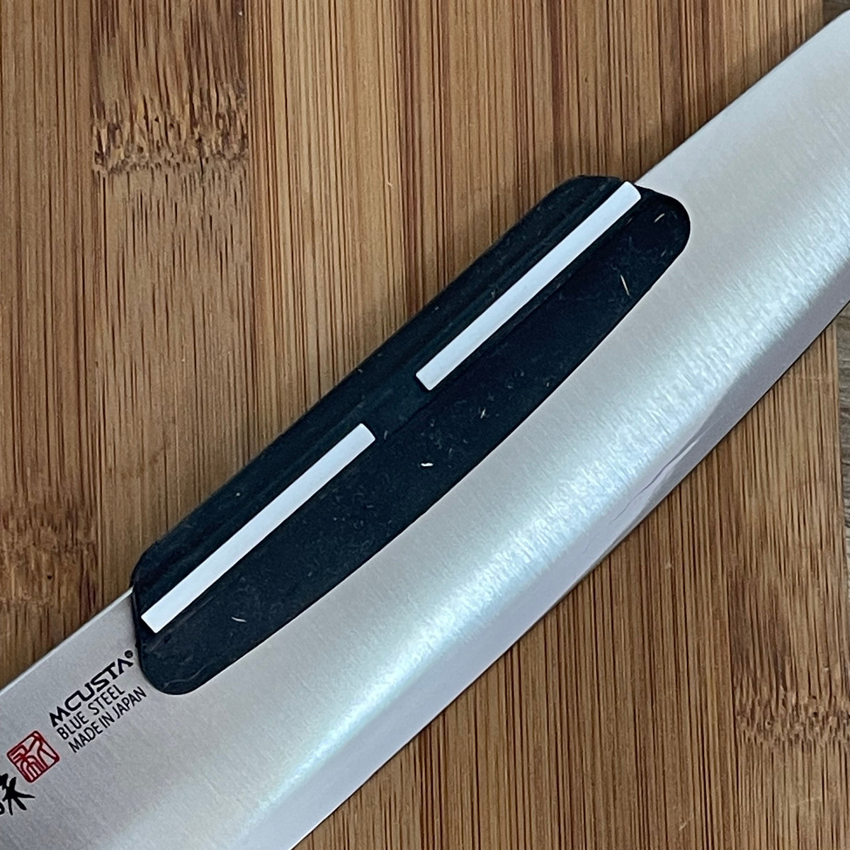 Guía de afilado con cuchillo insertado sobre piedra de afilar - uso correcto