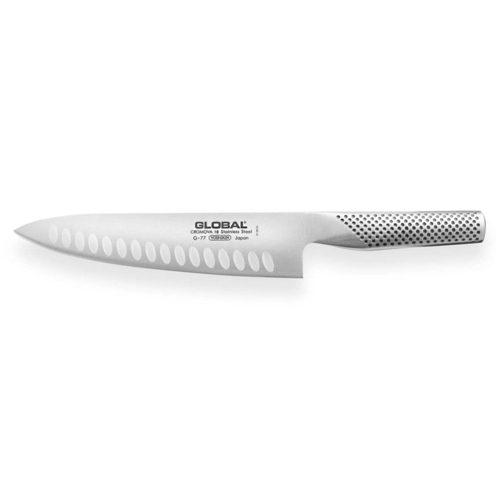 Mango con textura de hoyuelos del cuchillo Global G-77 y hoja CROMOVA 18 en primer plano